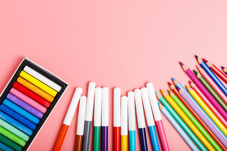 colored pencils, pastels, felt-tip pens on a pink background. concept for a hobby or drawing school...
