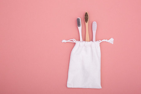 Eco-friendly bamboo wooden toothbrushes in a cotton bag. The concept of caring for the environment,...