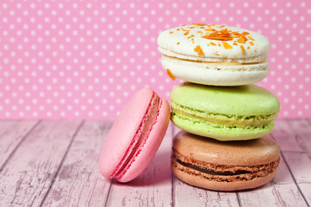 Traditional French dessert makarons on a colorful polka dots background