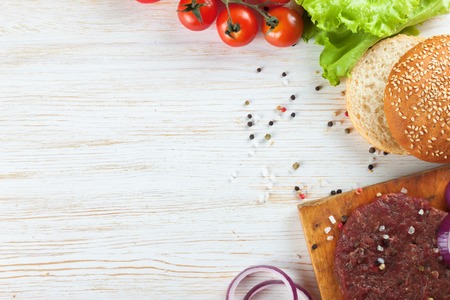 The raw ingredients for the homemade burger on white wooden table. Top view.の写真素材
