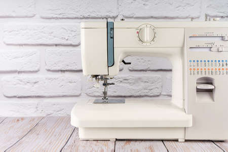 Modern sewing machine on white brick wall background. copy space for text.の写真素材