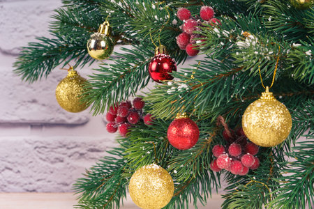 Decorated new year and christmas tree branches with snowflakes on white brick background.