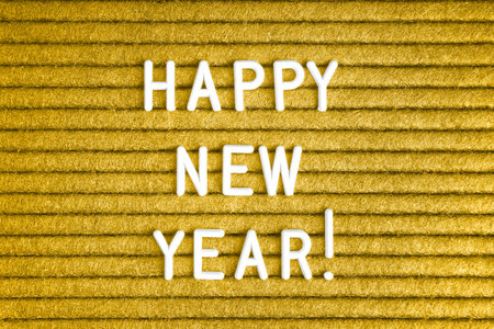 Happy new year , text on yellow felt letter board with white letters . Top view, flat lay
