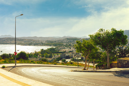 Turn of the road with view on the seaside city. Summer landscape in sunny day with blue sky. Turkey,...