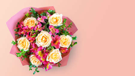 Bouquet of beautiful roses and alstroemeria on pink background with copy space. Floral shop conceptの写真素材