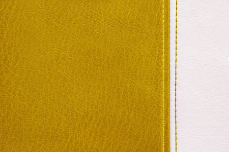 Natural, artificial yellow and white leather texture background with vertical decorative seam. Material for sports items, clothing, furnitre and interior design. environmentally friendly leatherette.の写真素材