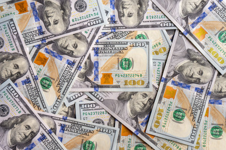 Pile of new design US dollar bills as background. Hundreds of dollar cash banknotes. Top view, flat...