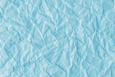 Recycled crumpled cyan paper texture background. Wrinkled and creased abstract backdrop, wallpaper with copy space, top view.の写真素材