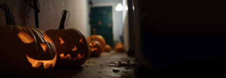 Halloween pumpkins in a spooky empty house, dark mysterious background. Header banner mockup with copy space. AI generated.の素材