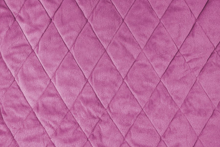 Quilted velours fabric background. Pink texture blanket or puffer jacket, stiched with diamond...