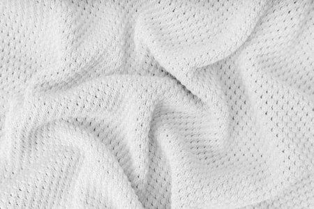 White color crumpled, wrinkled knitting wool cloth texture. Background of knitted fabric with dots...
