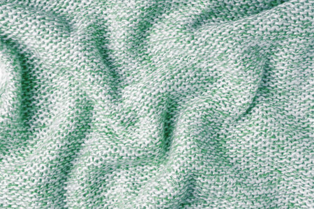 Green and white color melange knitting cashmere wool texture. Background of crumpled, wrinkled knit fabric, textile structure, cloth surface, weaving of knitwear material.の写真素材