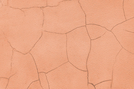 Old stucco plaster surface with cracks, close up grunge texture of orange painted cement, concrete wall texture background. Wallpaper, backdrop, architecture design elementの写真素材