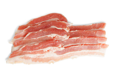 Piece of raw pork bacon close up, macro isolated on white background. Streaky brisket slices, fresh thin sliced bacon meat, food ingredientの写真素材