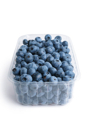 Fresh raw organic blueberries in transparent plastic container isolated on white background close up. Summer harvest of blueberry berries packed in disposable box, healthy foodの写真素材