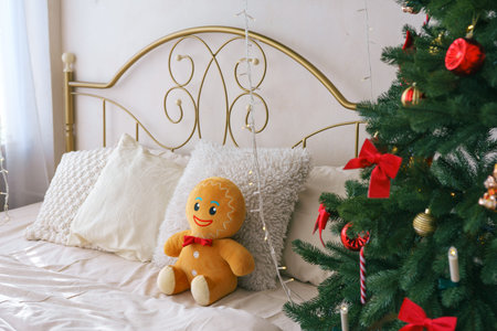 Cozy bedroom features beautifully decorated Christmas tree with ornaments and gingerbread plush toy...