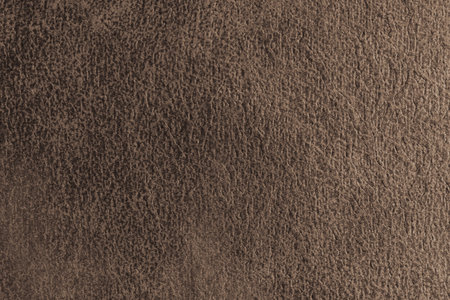 Close up, macro structure of brown suede fabric with abstract embossed shabby, messy texture. Upholstery, decorative cloth structure, canvas for home decor. Background, backdrop, wallpaper.の写真素材