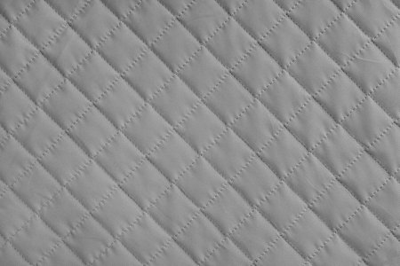 Checkered, diamond stitching pattern, gray quilted fabric background. Blanket or puffer jacket, stitch rhombus texture close up, macro. Wallpaper, backdrop.の写真素材