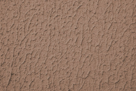 Close up of textured brown color painted wall with rough stucco, plaster wall texture. Vibrant background, wallpaper, backdrop, design element.の写真素材