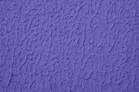 Close up of textured purple color painted wall with rough stucco, plaster wall texture. Vibrant...