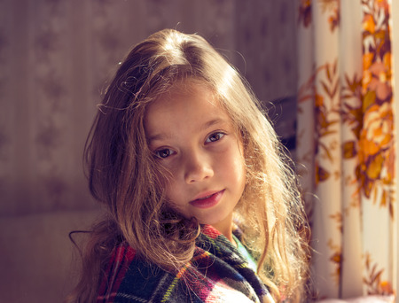 Adorable little girl awaked in cold sunny morningの写真素材