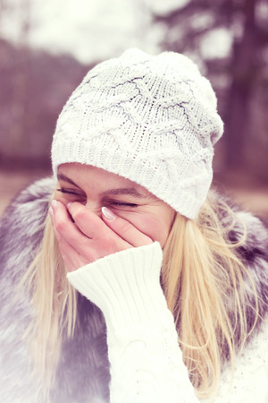 Toned portrait of pretty laughing girl in cold weatherの写真素材