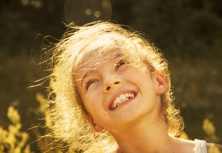 Cute girl smiling in the sunの写真素材