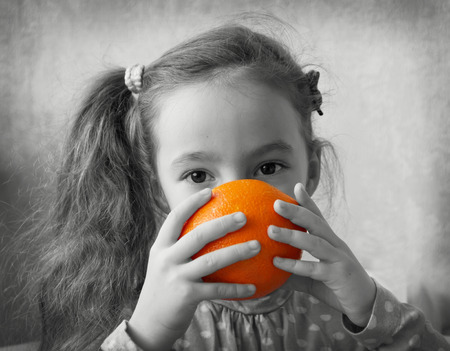 Cute girl play with orangesの写真素材