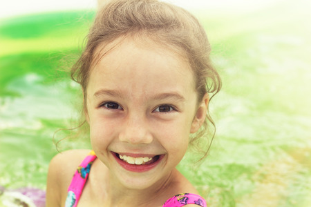 Toned portrait of Pretty little girl swimming in outdoor poolの写真素材