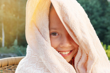 Cute little girl is drying off from swimming at summer dayの写真素材