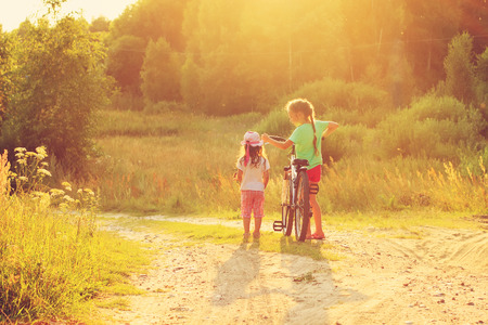 Cute little girls playing at sunny field on summer dayの写真素材