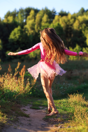  Beautiful teen girl  Is dancing outside at  summer sunset  の写真素材
