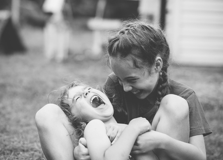 Two Happy little girls laughing and hugging at the  summer park. Black and white photoの写真素材