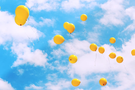 Balloons in the blue sky flying away. Toned, soft focused.の写真素材