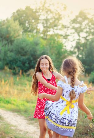 Two Happy cute  little girls having fun and dancing at sunny summer day outdoorsの写真素材