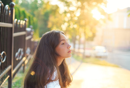 Portrait of a cute teenager girl is dreaming and having fun outdoors at summer eveningの写真素材