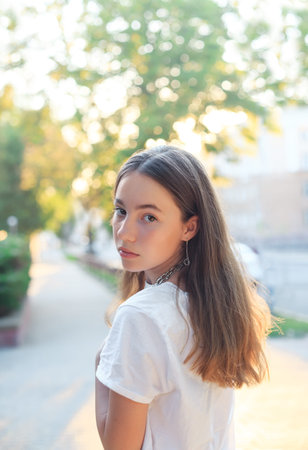 Portrait of teen girl is dreaming and having fun outdoors at summer eveningの写真素材