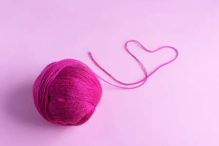 Pink knitted wool on a pink background, hobbyの写真素材
