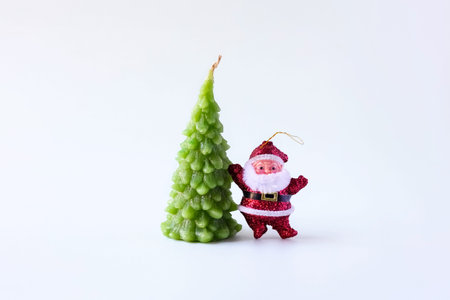 Christmas composition of a candle in the shape of a Christmas tree and Santa Claus on a gray background, the concept of New year and Christmas, front viewの写真素材