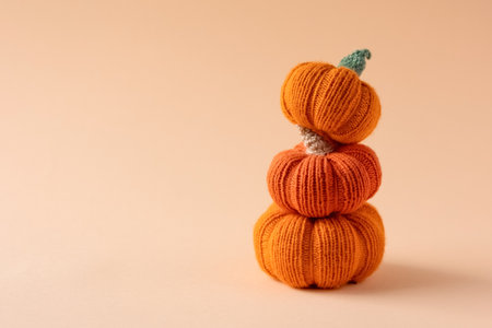 Knitted orange pumpkins on an orange background, autumn composition, front view. Halloween concept.の写真素材