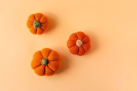 Knitted orange pumpkins on an orange background, autumn composition. Halloween concept.の写真素材