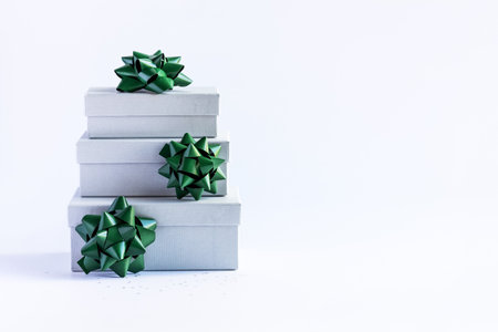 Christmas composition of a gray gift box with a green bow on a gray background with starsの写真素材
