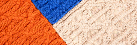 Knitted blue orange and beige background. Large knitted fabric with a pattern. Close-up of a knitted...