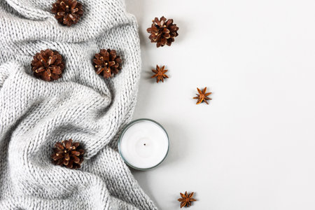 Winter cozy composition of knitted sweaters, candles, pine cones, stars of star anise.の写真素材