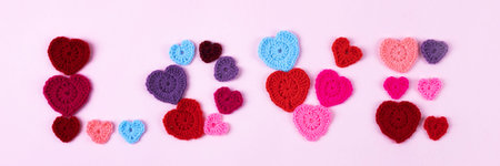 Happy Valentines Day, Mothers Day and birthday greeting card. Multicolored crocheted hearts are laid...