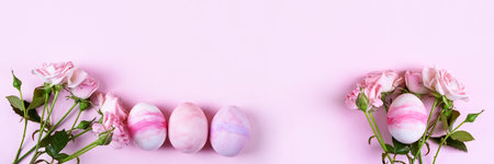 Pale pink Easter eggs with a sprig of pink roses on a pink background. Happy Easter concept. Greeting card, copy space. Bannerの写真素材