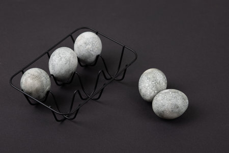 Grey Easter eggs in a black stand on a black background. Minimal Easter conceptの写真素材