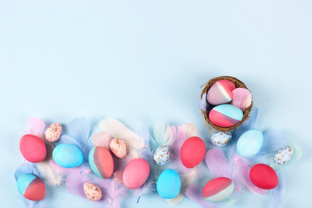 Painted Easter eggs in crimson and blue on a blue background with a place for text. Happy Easter...