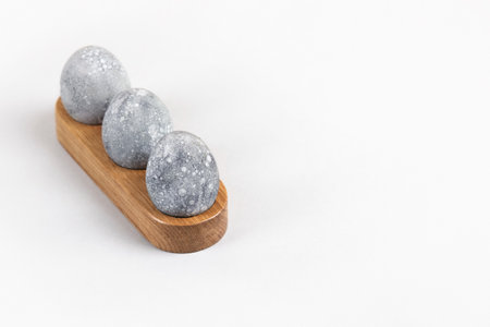 Grey Easter eggs in a wooden stand on a gray background. Minimal Easter conceptの写真素材