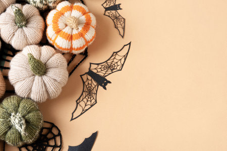Halloween greeting card mockup with copy space. Halloween decorations, bats, knitted webs, pumpkins on beige background. Happy Halloween holiday concept. Flat lay, top viewの写真素材